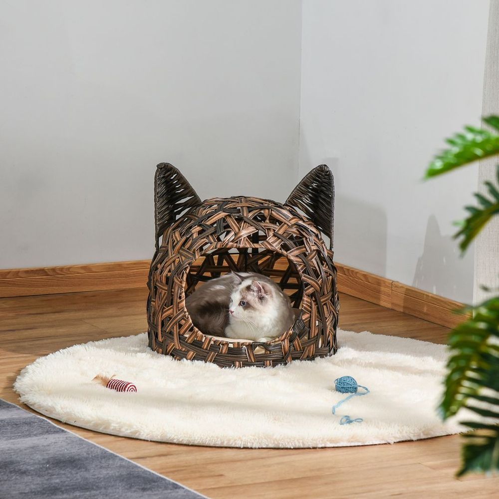 Cat sitting inside a cat shaped bed